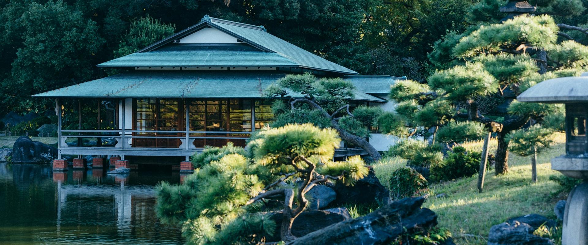 Traditional teahouse beside a pond in a Japanese landscape garden