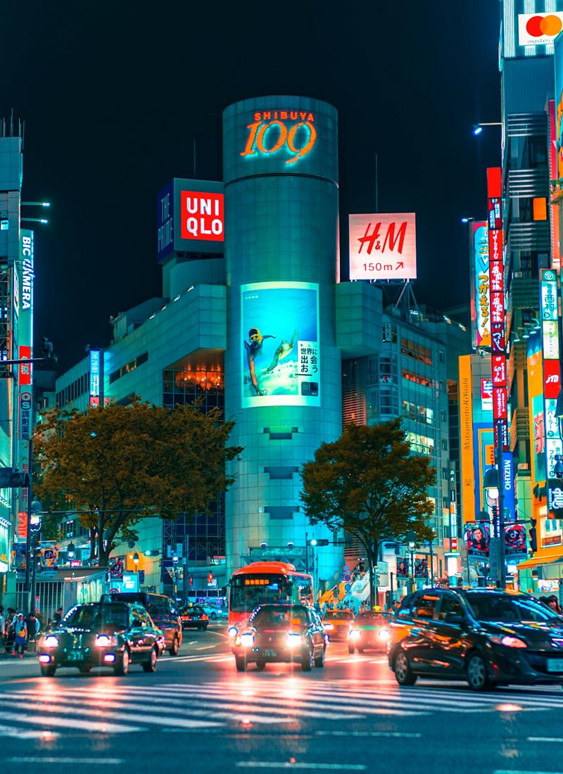Shibuya crossing glowing with neon signs at night